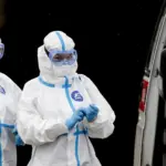 Медичний працівник у захисному костюмі біля карантинного медичного закладу (ілюстративне фото REUTERS/Anastasia Barashkova)
